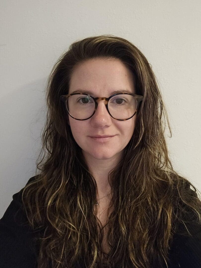 Portrait photo of Natalie Wintle, long dark hair and glasses